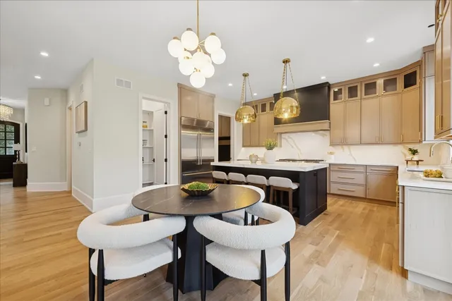 a kitchen with granite countertop a table chairs stove and cabinets