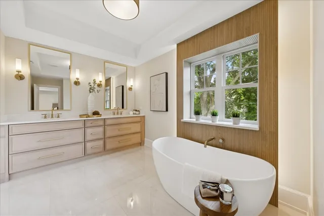 a bathroom with a tub a sink and a window