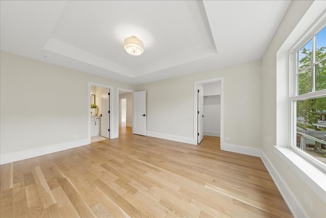 a view of empty room with window and wooden floor