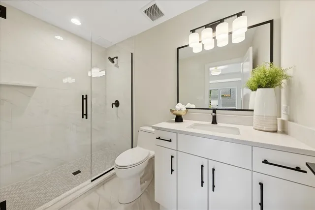 a bathroom with a toilet a sink and shower