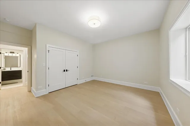 an empty room with windows and entrance to other room