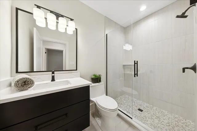 a bathroom with a sink a toilet and shower