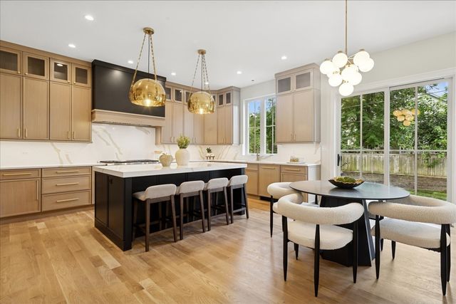 a kitchen with kitchen island granite countertop a sink counter and chairs