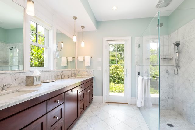 a bathroom with a granite countertop sink mirror and shower