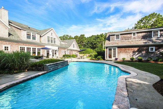 a view of a house with pool and chairs