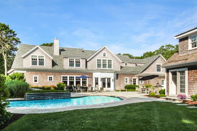a front view of a house with swimming pool having outdoor seating