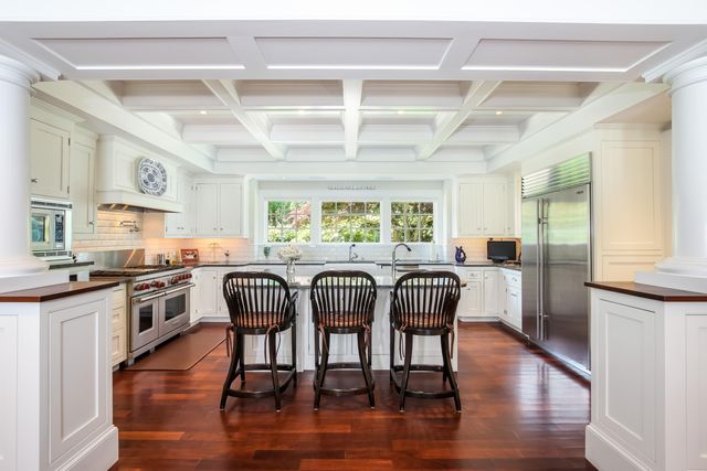 a kitchen with stainless steel appliances granite countertop wooden floors and white cabinets