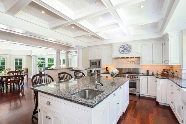 a kitchen with stainless steel appliances granite countertop a sink a stove and cabinets