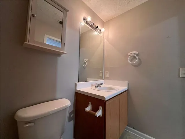 a bathroom with a sink toilet and mirror