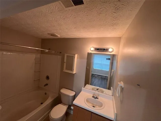 a bathroom with a toilet a sink and shower