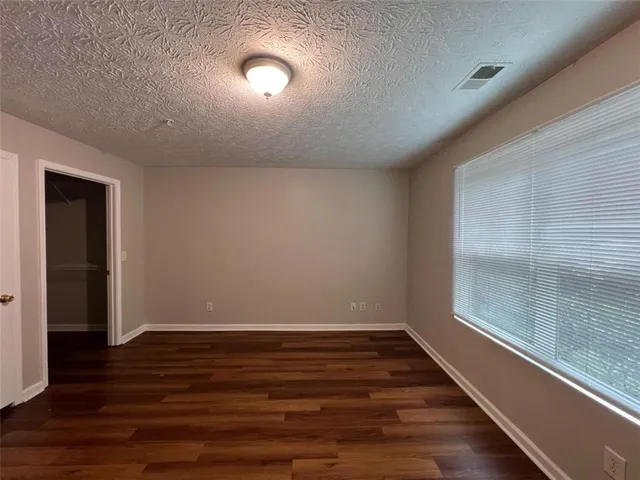 a view of room with window and wooden floor