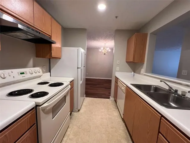 a kitchen with a stove sink and cabinets