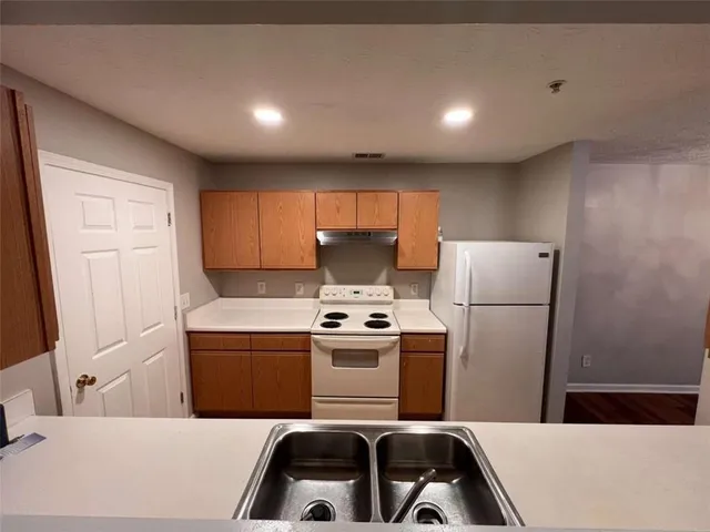 a kitchen with a stove a refrigerator and a sink