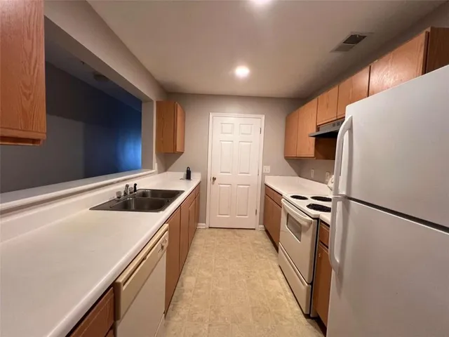 a kitchen with stainless steel appliances a sink a stove a refrigerator and cabinets