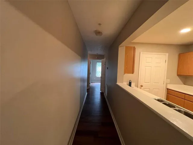 a view of a hallway with wooden floor and staircase