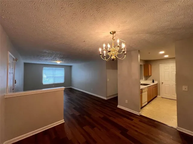 a view of a kitchen with wooden floor and stainless steel appliances
