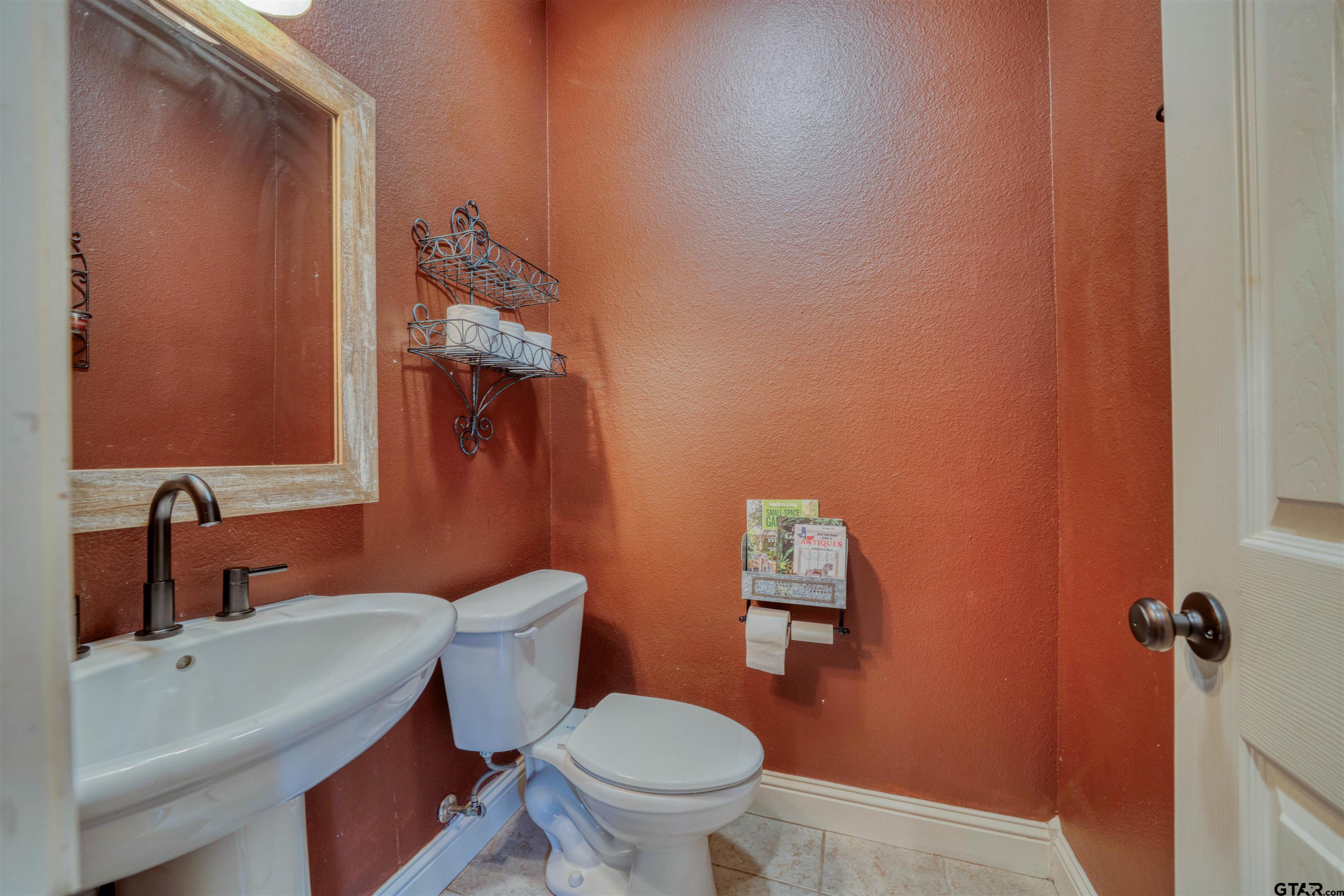 1776 Mustang Road Gilmer, TX 75645 - Photo 30 of 45 a bathroom with a toilet a sink and mirror
