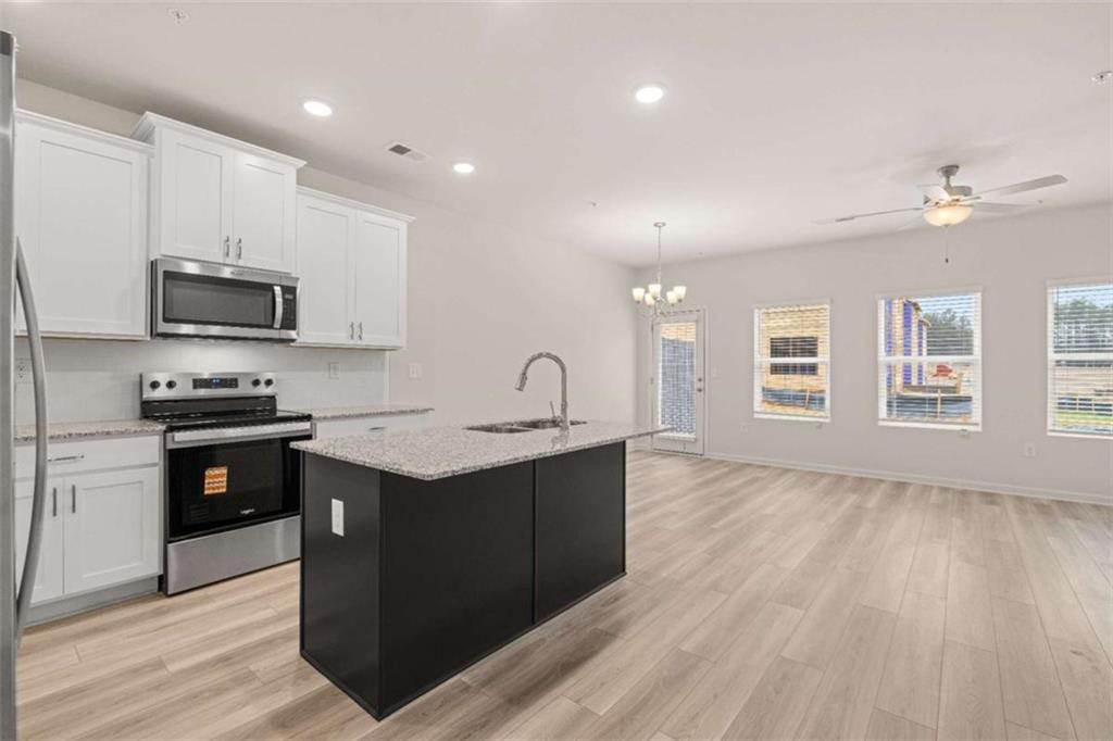 9452 Maple Grv Lane Jonesboro, GA 30238 - Photo 7 of 23 a kitchen with stainless steel appliances kitchen island granite countertop a stove a sink and a refrigerator