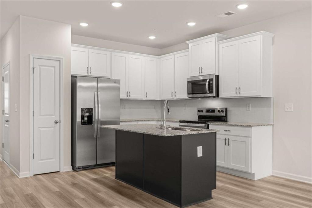 9452 Maple Grv Lane Jonesboro, GA 30238 - Photo 8 of 23 a kitchen with stainless steel appliances granite countertop a refrigerator a sink a stove a microwave and white cabinets