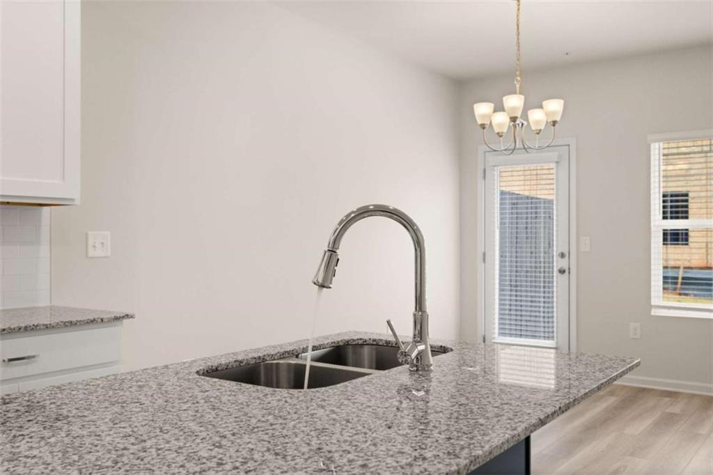 9452 Maple Grv Lane Jonesboro, GA 30238 - Photo 9 of 23 a kitchen with a sink and chandelier
