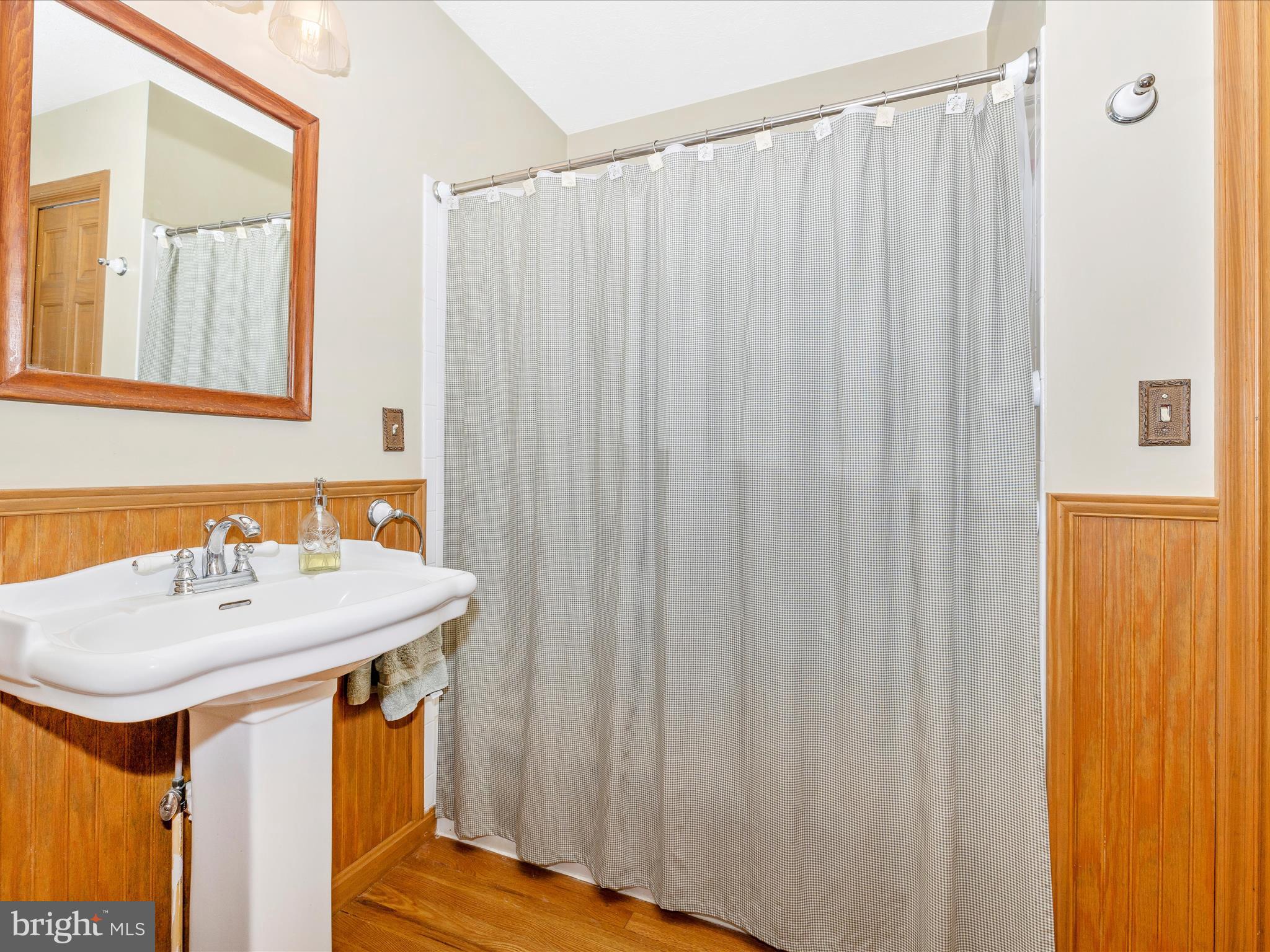 8560 Rocky Springs Road Frederick, MD 21702 - Photo 23 of 50 a bathroom with a sink a mirror and a shower curtain