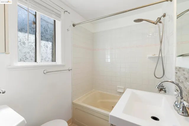 a bathroom with a sink a window and a shower
