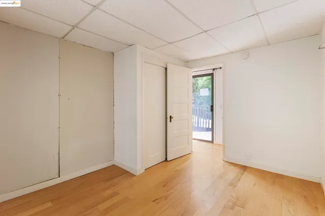 a view of an empty room with closet and a window