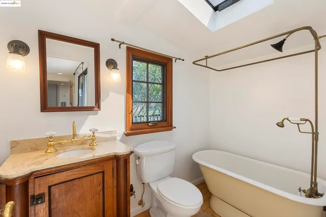 a bathroom with a sink a mirror toilet and bathtub
