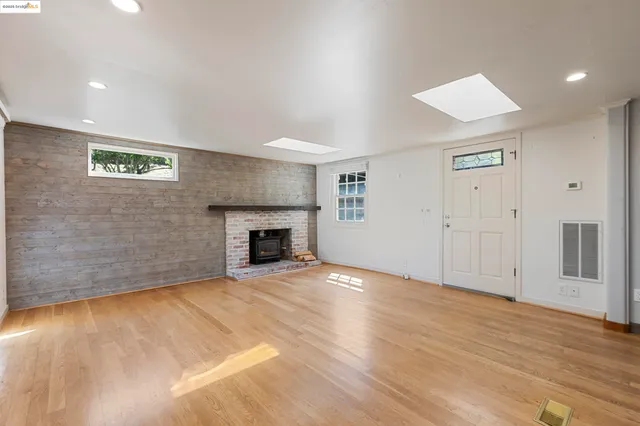 a view of empty room with wooden floor and fireplace