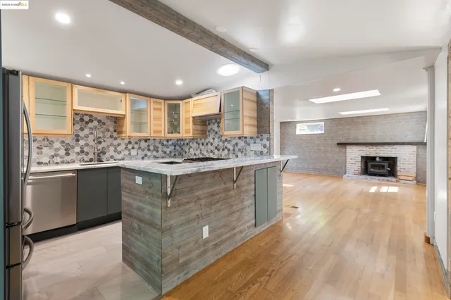 a kitchen with stainless steel appliances granite countertop a wooden cabinets and a counter top space