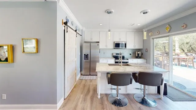 a kitchen with stainless steel appliances kitchen island granite countertop a refrigerator and a stove top oven