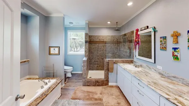 a spacious bathroom with a tub sink and mirror