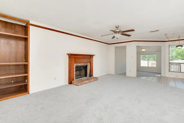 an empty room with windows and ceiling fan
