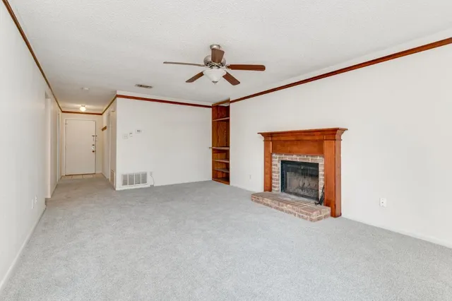 a view of empty room with fireplace and fan