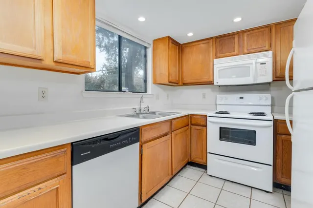 a kitchen with stainless steel appliances granite countertop a sink a stove a refrigerator with grey cabinets