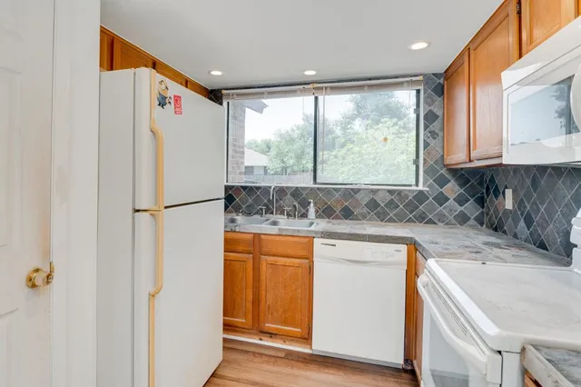 a kitchen with stainless steel appliances granite countertop a refrigerator and a sink