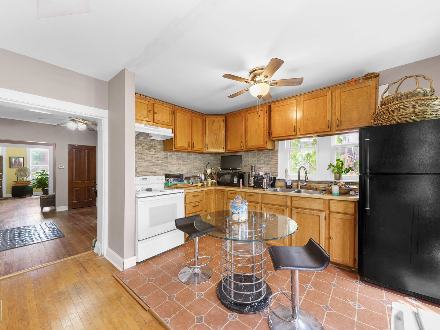 11349 South St Lawrence Avenue, Unit ROWHSE Chicago, IL 60628 - Photo 10 of 22 a kitchen with stainless steel appliances granite countertop a refrigerator a sink a stove cabinets and a dining table