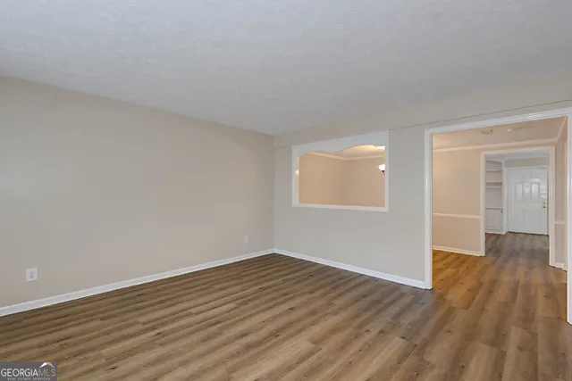 a view of an empty room with wooden floor