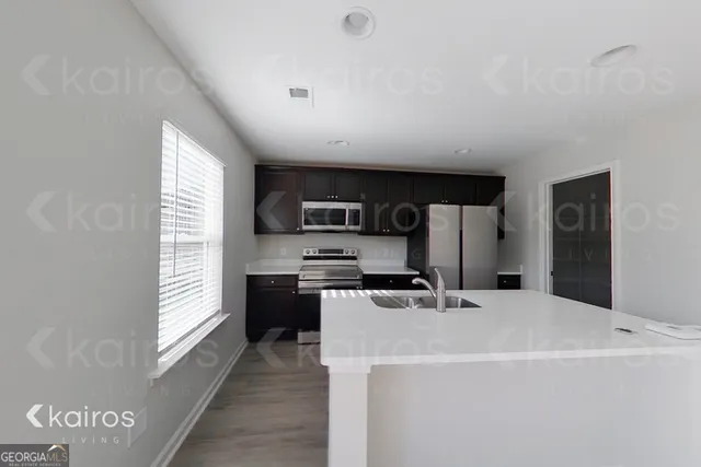 a kitchen with stainless steel appliances a refrigerator a sink a stove a microwave and cabinets