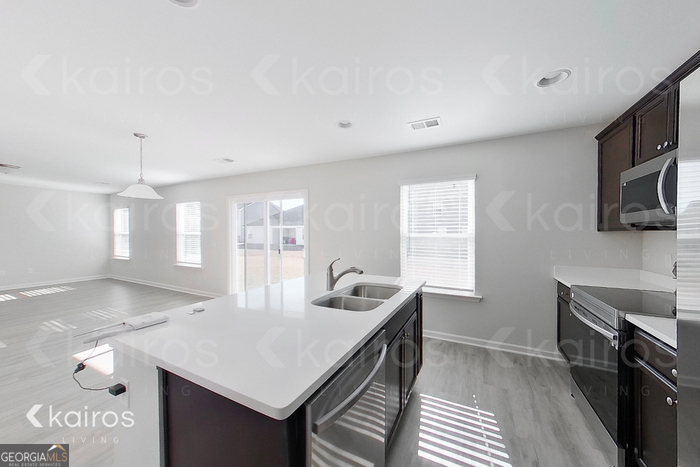 18 Duluth Drive Brunswick, GA 31525 - Photo 9 of 26 a kitchen with granite countertop a sink a stove cabinets counter space and a window