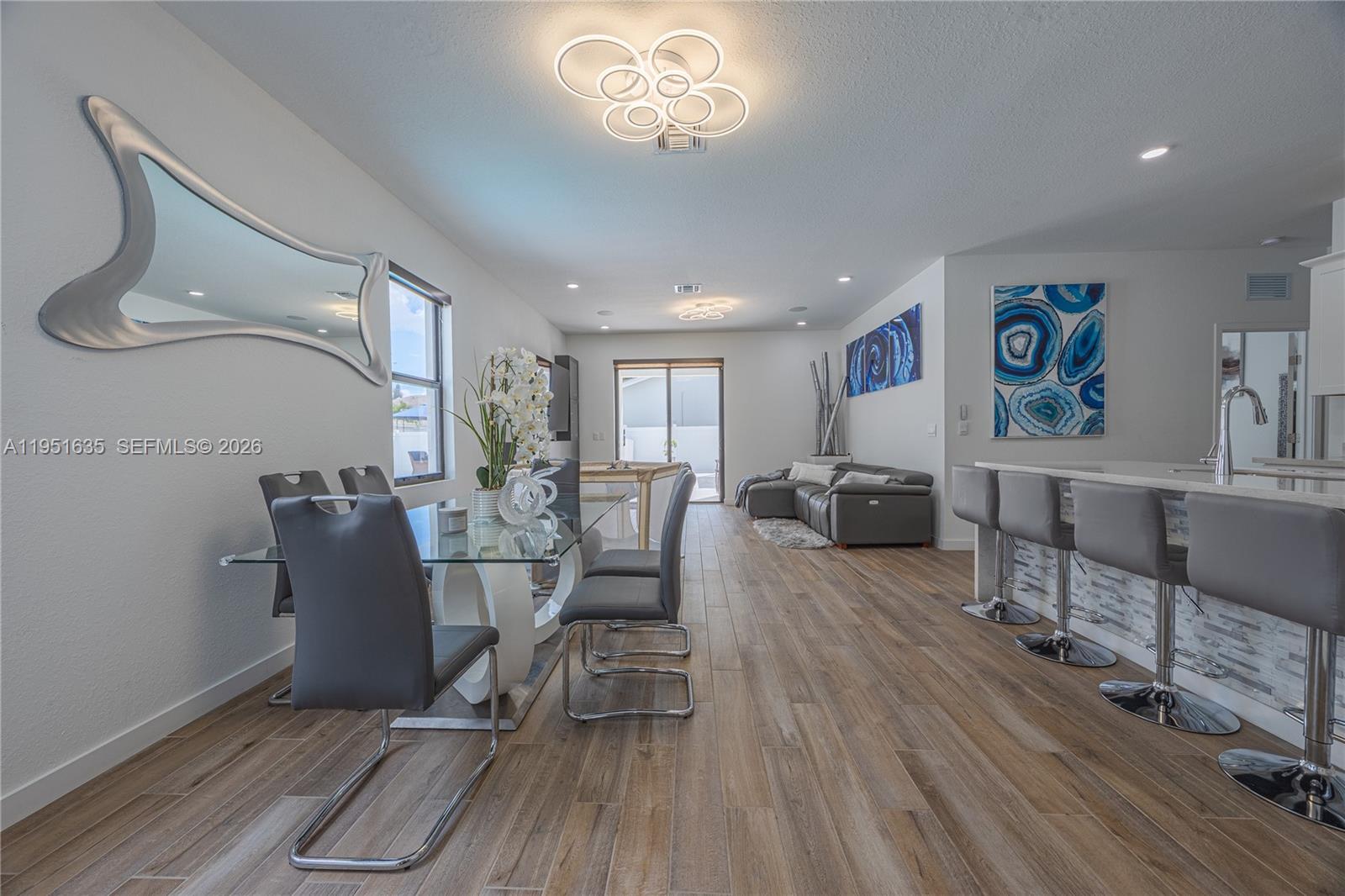 7126 Rockwood Road Jupiter, FL 33458 - Photo 17 of 30 a living room with furniture a dining table and a wooden floor