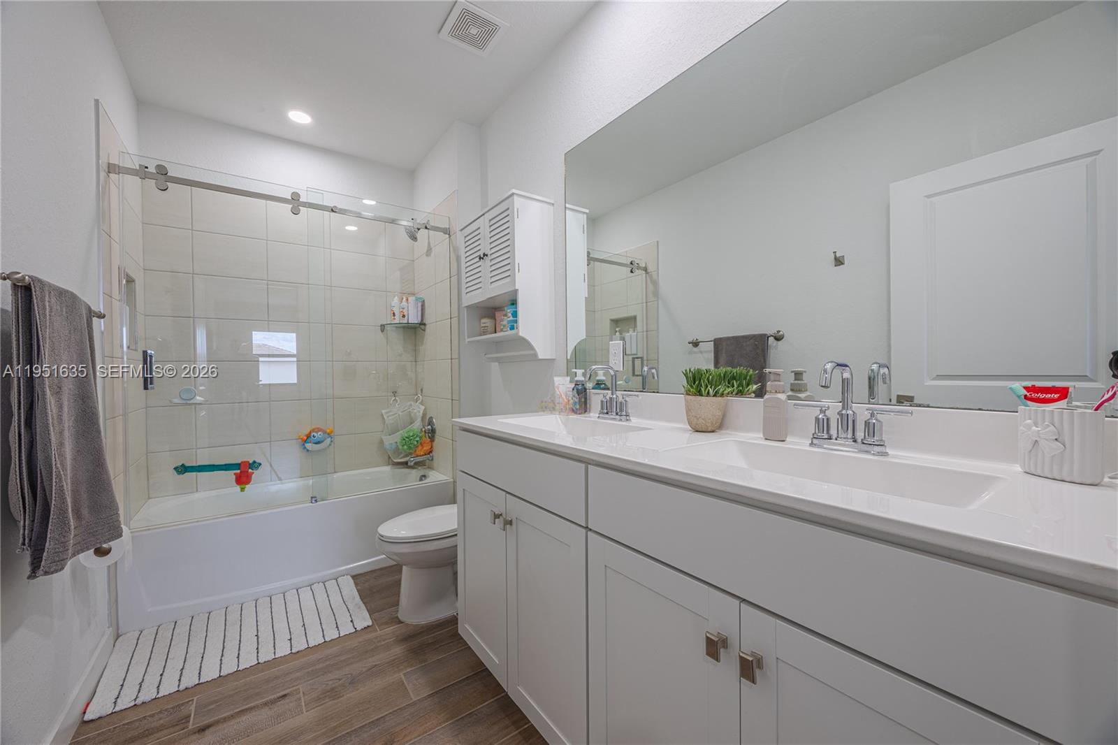 7126 Rockwood Road Jupiter, FL 33458 - Photo 25 of 30 a bathroom with a sink a toilet a mirror and shower