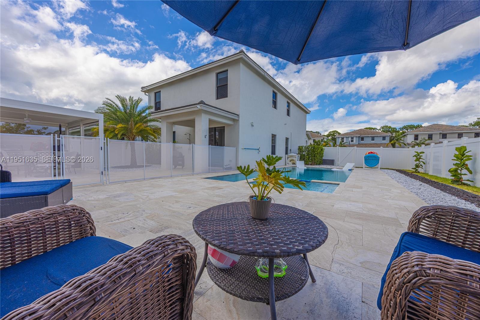 7126 Rockwood Road Jupiter, FL 33458 - Photo 3 of 30 a view of a patio with a table chairs and a potted plant