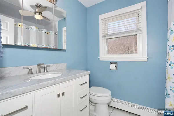 a bathroom with a granite countertop sink a toilet and a mirror