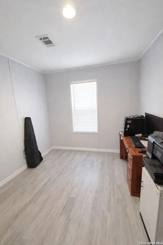 a view of a workspace with furniture and a window