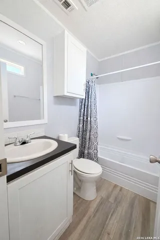 a bathroom with a sink toilet a mirror and shower