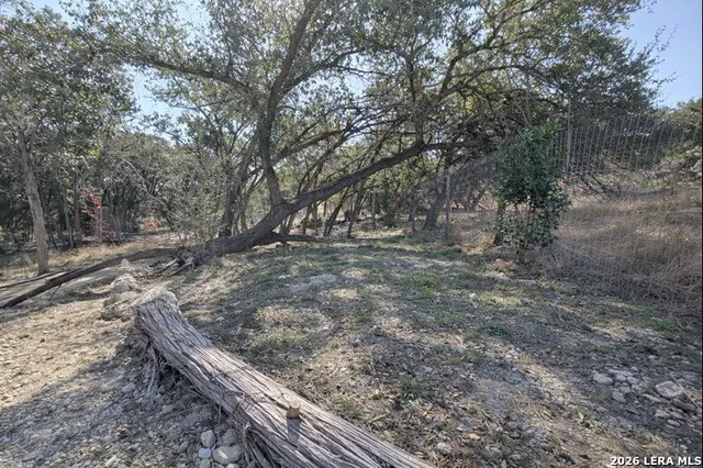 a view of a yard with wooden fence