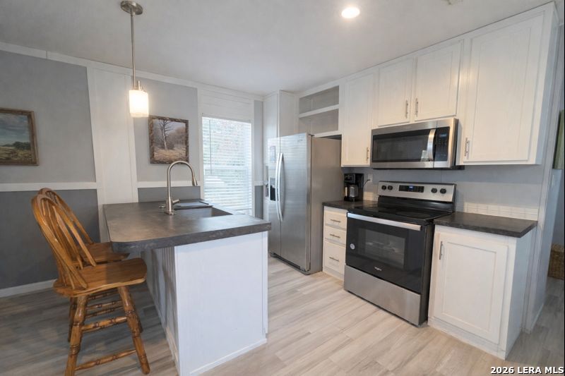 721 Tejas Trail Bandera, TX 78003 - Photo 5 of 17 a kitchen with stainless steel appliances kitchen island granite countertop a sink refrigerator and microwave