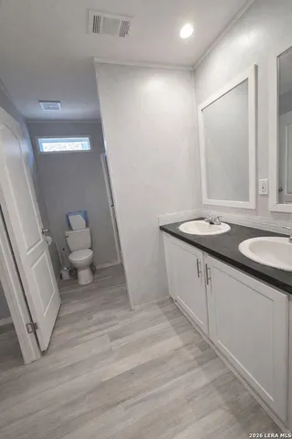 a spacious bathroom with a granite countertop sink and a mirror