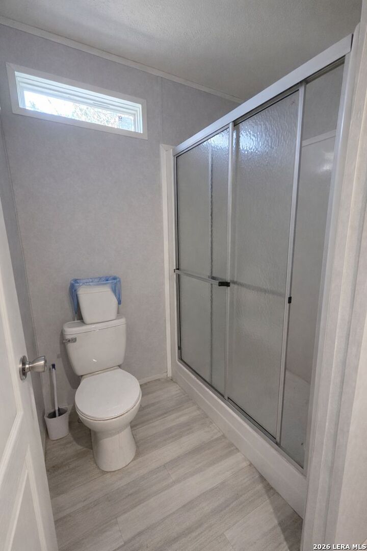 721 Tejas Trail Bandera, TX 78003 - Photo 10 of 17 a bathroom with a toilet and a shower
